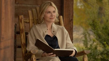Michelle Pfeiffer sits in a rocking chair holding a book